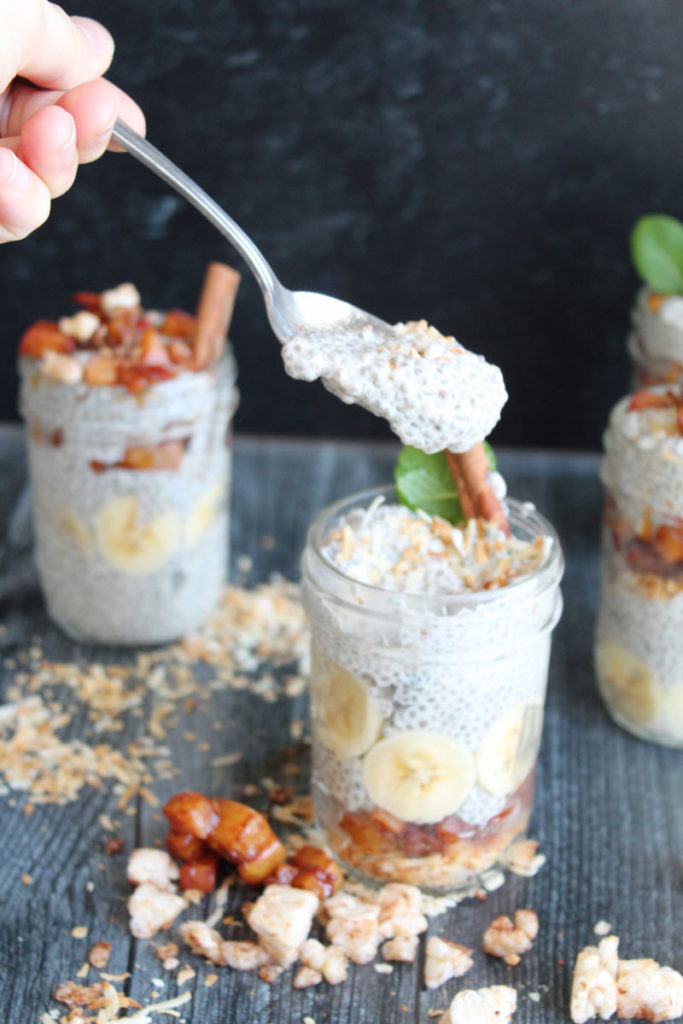 A hand scooping chia cereal from a mason jar
