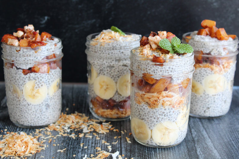 A display of four chia cereals in mason jars and toasted coconut sprinkled around them