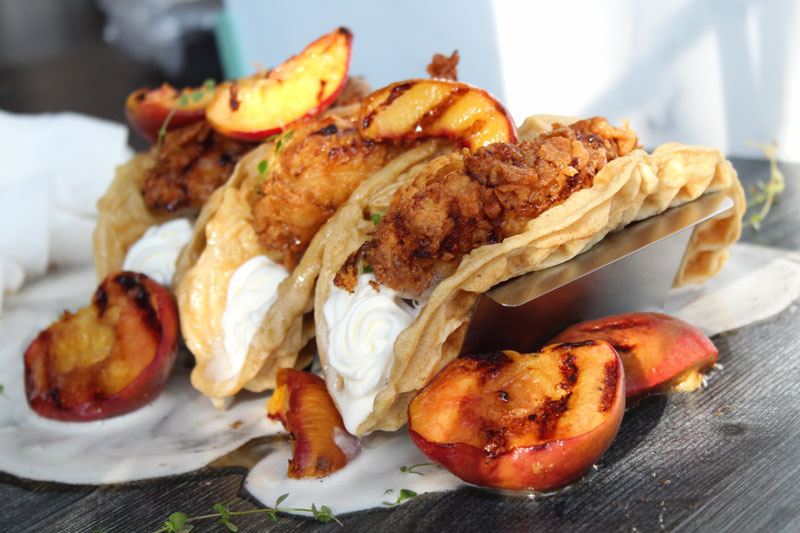 three fried chicken and waffle tacos on a taco holder